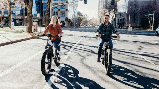 Un homme et une femme faisant du vélo électrique